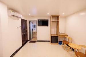Habitación con cocina, mesa y sillas. en Happy Hotel en Bạc Liêu