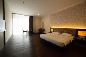 a hotel room with a large bed and a table at Waterfront Boutique Hotel in Port Dickson