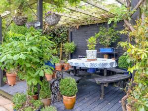 a patio with a table and some potted plants at 5 Church Square in Rigg