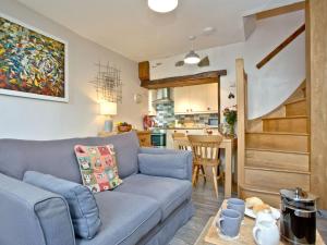 阿普多爾的住宿－Cobble Cottage，一间带蓝色沙发的客厅和一间厨房