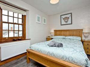 um quarto com uma cama e uma janela em Cobble Cottage em Appledore