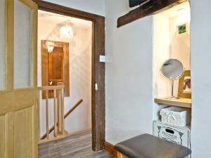 um corredor com uma porta, uma cadeira e um espelho em Cobble Cottage em Appledore