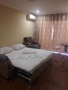 una camera da letto con un letto, una sedia e un tavolo di Сергей Сергеевич a Akhaltsikhe