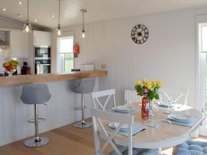 a kitchen and dining room with a table and chairs at Willow Lodge - Uk13637 in Creetown