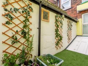 a garden with ivy on the side of a building at Hodges - Uk30761 in Gorleston-on-Sea