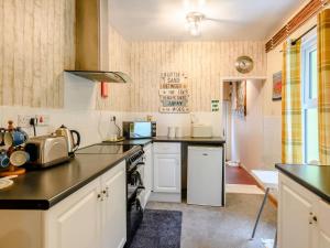 a kitchen with white cabinets and a stove top oven at Hodges - Uk30761 in Gorleston-on-Sea