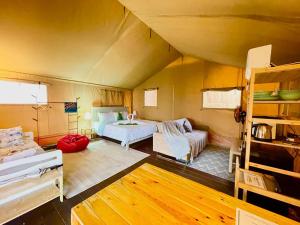 a bedroom with a bed and a couch in a room at Rembulan Escape - Beachfront safari tent in Penarek
