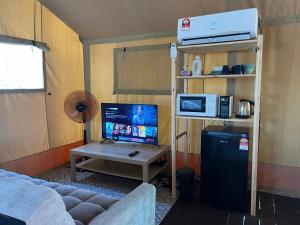 カンポン・ペナリックにあるRembulan Escape - Beachfront safari tentのリビングルーム(ソファ、デスク、コンピュータ付)