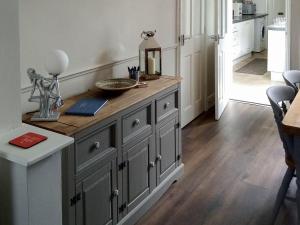 a kitchen with a large wooden cabinet with a counter top at Pankhurst in Louth