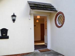 a hallway of a white house with a door and a mirror at Wernyfed in Sennybridge