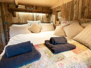 a large bed with two pillows on top of it at The Shepherds Hut At Gowan Bank Farm in Staveley