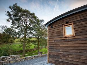 a wooden building with a window on the side of it at The Shepherds Hut At Gowan Bank Farm in Staveley