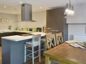 a kitchen with a table and some chairs and a counter at Alnwick Old Brewery Apartment in Alnwick