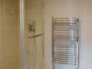 a shower with a glass door in a bathroom at Alnwick Old Brewery Apartment in Alnwick