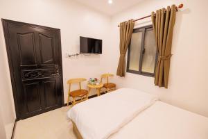 Schlafzimmer mit einem Bett, einem Fenster und einem Tisch in der Unterkunft Happy Hotel in Bạc Liêu
