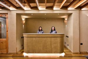 zwei Frauen, die hinter einem Tresen in einer Lobby stehen in der Unterkunft Pal Hotel in Leh