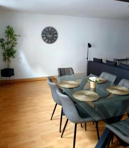 a dining room with a table and chairs and a clock at Hotel Apartment Ferienwohnung Meyenhof Frankenberg Eder in Frankenberg