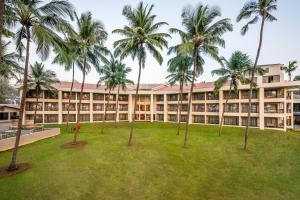 达曼Silver Waves Resort & Spa - Daman的享有棕榈树建筑的外部景色