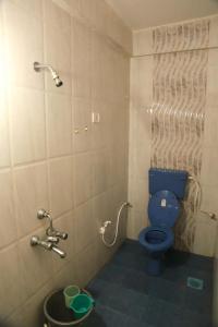 y baño con aseo azul y ducha. en Dreamcatcher House & Hostel at Arambol Beach, en Arambol