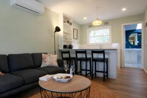 a living room with a couch and a table at Sahara Trails Cabin 1 WiFi Air Conditioning Horse Riding and much more in Anna Bay