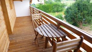 a wooden balcony with a wooden bench on a deck at Levendula apartman in Kehidakustány