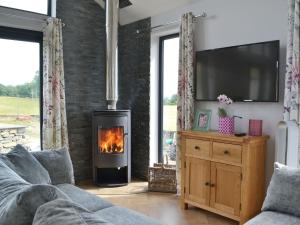 a living room with a fireplace and a couch at Sprint Lodge in Burneside