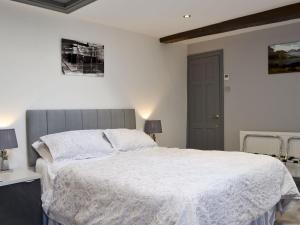 a bedroom with a large bed with a white comforter at The Milking Parlour - Uk30866 in St Bees
