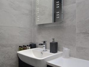 y baño con lavabo blanco y espejo. en The Milking Parlour - Uk30866, en St Bees