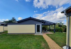 a detached house with a pitched roof and a patio at Ferienhaus am Luckower See in Sternberg