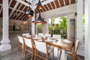 a dining room with a wooden table and chairs at Villa Little Mannao in Kerobokan
