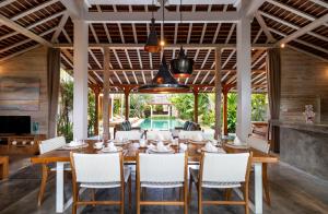 Villa Little Mannao في كيروبوكان: غرفة طعام مع طاولة وكراسي خشبية