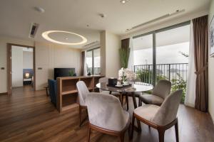 een woonkamer met een tafel en stoelen en een televisie bij Flamingo Premium Lan Ha Bay Resort in Hai Phong