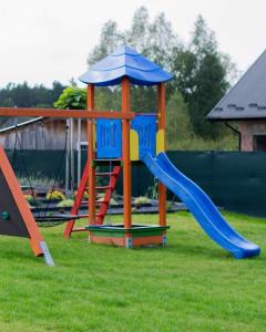 a playground with a slide in the grass at Krzaczasty Zakątek in Zdziary