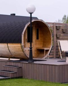 a wooden play house with a slide on a deck at Krzaczasty Zakątek in Zdziary