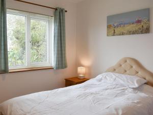 a bedroom with a white bed with a window at Belmont in Longton