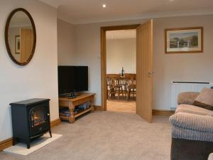 a living room with a fireplace and a television at Stonehaven Cottage in West Tanfield