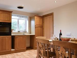 a kitchen with a table and some chairs and a counter at Stonehaven Cottage in West Tanfield