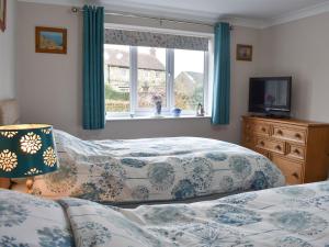 a bedroom with two beds and a window at Stonehaven Cottage in West Tanfield