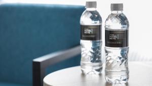 two bottles of water sitting on top of a table at JR-East Hotel Mets Musashisakaii in Musashino