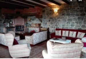 restauracja z białymi krzesłami i kamienną ścianą w obiekcie La Rectoral de Valdedios.Casa rural con chimenea 
