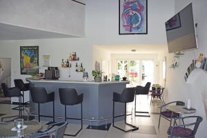 a bar in a room with chairs and tables at Wellness Appartements in Ihlowerfehn