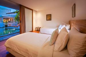 una camera con due letti e una piscina di Bias Villa Seminyak a Seminyak Altre 115 foto