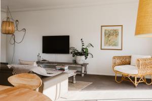 a living room with a tv and a couch and a chair at Bay Breeze Boutique Accommodation in Batemans Bay