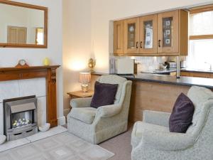 a living room with two chairs and a fireplace at The Gatehouse - Uk2482 in Cayton
