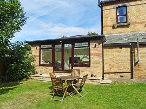 a table and chairs in front of a house at The Gatehouse - Uk2482 in Cayton