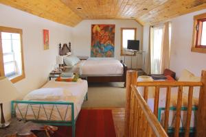 sypialnia z 2 łóżkami i telewizorem w obiekcie SnowMansion Taos Adventure Lodge w mieście Arroyo Seco
