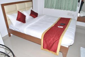 a bed with red pillows on it in a room at HOTEL THE ROYAL PARK in Bangalore