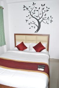 a bedroom with a bed with a tree on the wall at HOTEL THE ROYAL PARK in Bangalore