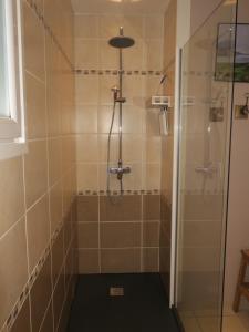 uma casa de banho com um chuveiro e uma porta de vidro em Chambres au grand calme dans maison em Primarette