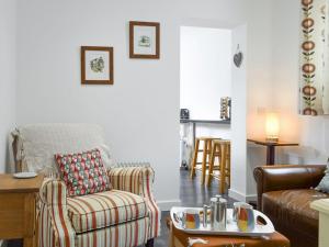 ein Wohnzimmer mit einem Sofa und einem Stuhl in der Unterkunft The Milk Place in Harby